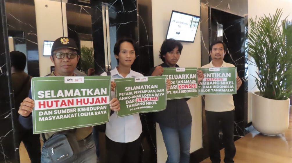 vier Männer mit Poster "Rettet den Regenwald und die Existenzquellen der Menschen von Loeha Raya"