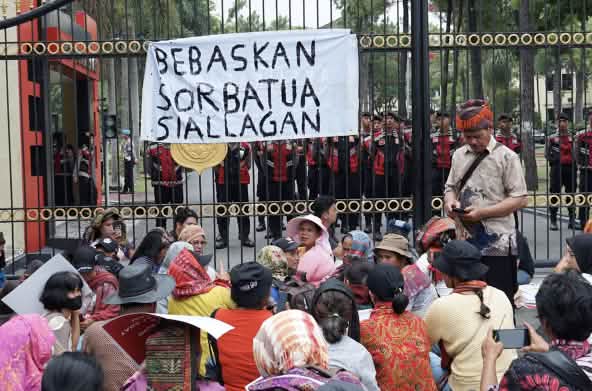 Demo vor hohem Zaun mit Banner "Sorbatua Siallagan freilassen"
