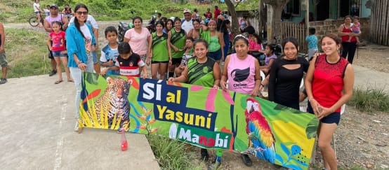 Eine Gruppe von Personen hält einen Banner mit der Aufschrift "Ja zu Yasuní Manabí" hoch