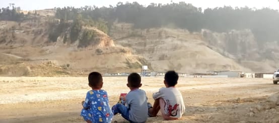 drei Kinder blicken auf Sandabbau