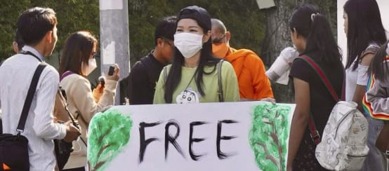 Eine junge Unterstützerin in Phnom Penh fordert die Freilassung der Aktivistinnen und Aktivisten (© MNC) Aktivistin hält großes Plakat in die Kamera mit dem Text „Free Mother Nature Activist!