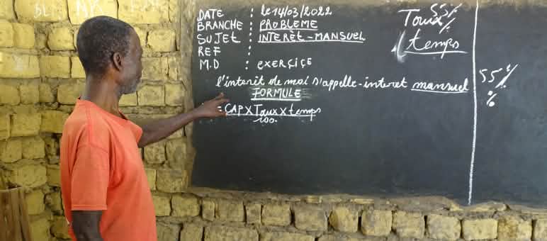 Unterricht im Dorf Bekombo - der Lehrer erklärt monatliche Zinsen Lehrer in einer Dorfschule in der Demokratischen Republik Kongo