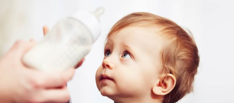 Verbraucherschützer gegen Palmöl Ein Baby wehrt mit sorgenvollem Blick eine ihm hingehaltene Trinkflasche ab