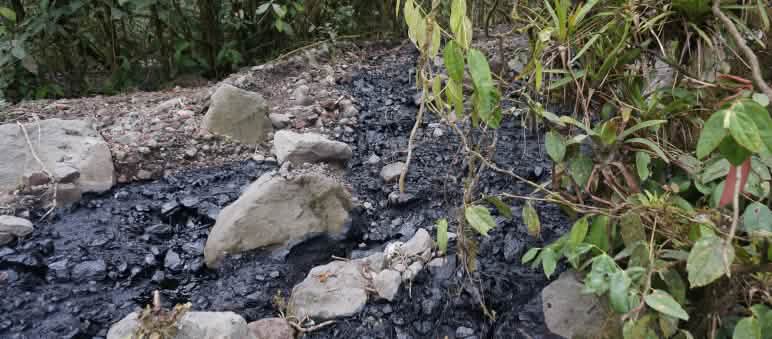 Erdöl vergiftet Amazonas (Foto: http://thepeoplesrecord.com) Über eine mit Schotter und Steinen bedeckte Fläche hat sich ein Strom von schwarzem Rohöl ergossen