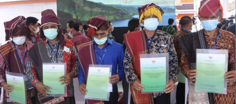 Präsident Joko Widodo persönlich hat die Urkunden der Anerkennung des Indigenen-Waldes überreicht 5 Männer mit Batak-Kleidung zeigen Urkunden