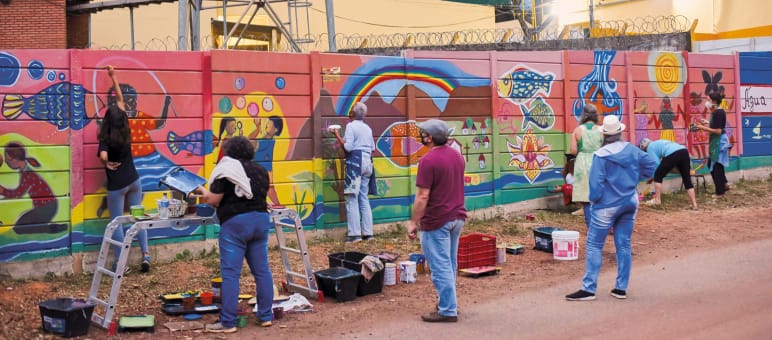 Die öffentliche Schmähung gegen die Anti-Bergbau-Aktivistin Carolina de Moura wurde von Frauen, Männern und Kindern kunstvoll übermalt Wandmalerei als Widerstand gegen Bergbau in Brumadinho, Brasilien
