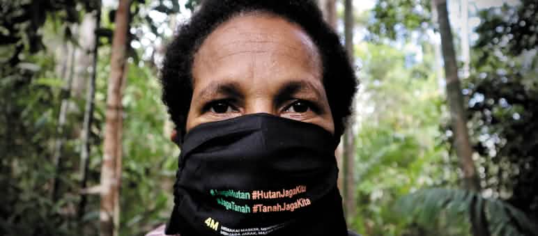 "Schützt den Wald - der Wald schützt uns" Papua-Frau mit Mundschutz "Schütz den Wald - der Wald schützt uns"