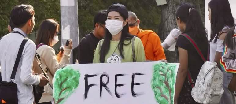 Sim Somnang, Try Sovikea und San Mala (von links) nach ihrer Freilassung Aktivistin hält großes Plakat in die Kamera mit dem Text „Free Mother Nature Activist!