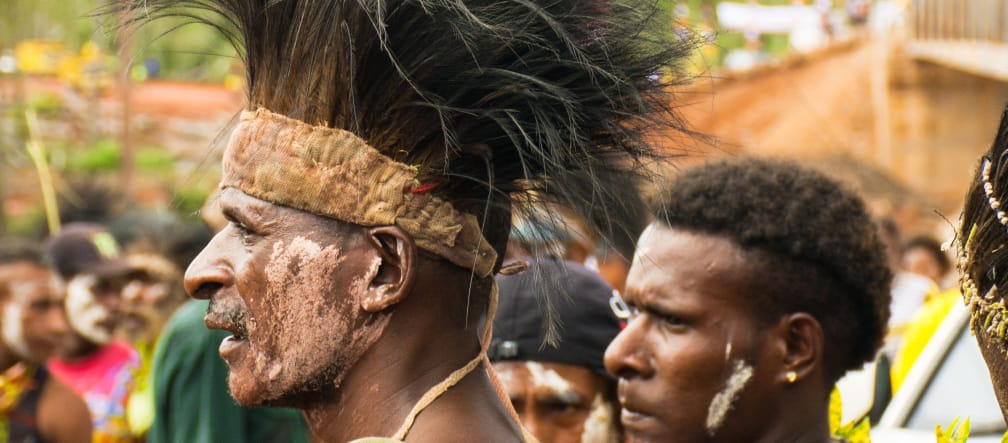 Die Mahuze wehren sich gegen Plantagen Männer mit Kopfschmuck bei einem Fest in Papua