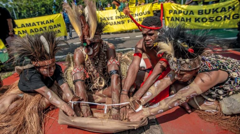 vier Papua mit Federschmuck halten ein Ritual ab. "Papua ist kein leeres Land"