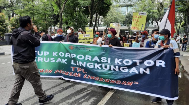 Fotograf und Demonstranten mit grünem Banner