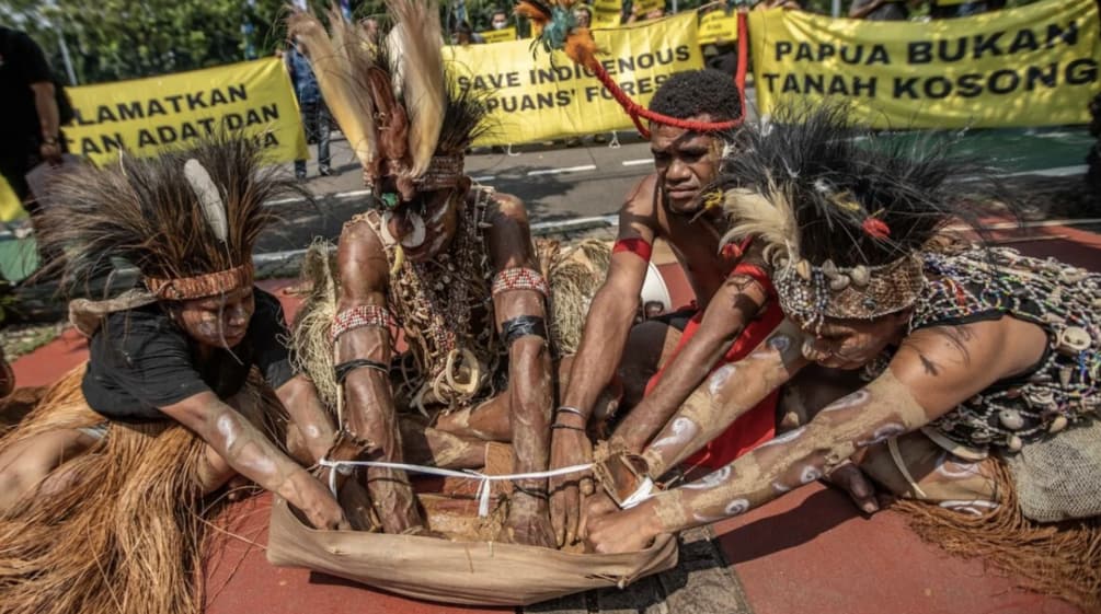 vier Papua mit Federschmuck halten ein Ritual ab. "Papua ist kein leeres Land"