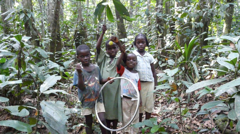 Vier Kinder spielen im Regenwald.