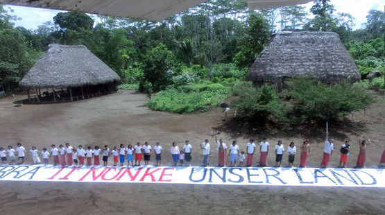 Die Indianer in einem Dorf im Amazonasregenwald richten sich mit einem Banner an die ffentlichkeit: Dies ist unser Land.